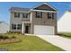 Two-story home with a brick and siding facade, a two-car garage, and a well-manicured lawn at 170 Aster Ave, Locust Grove, GA 30248