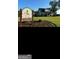 Community clubhouse with signage, manicured lawn, and mature trees at 759 Hennepin Ter, Mcdonough, GA 30253