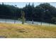 A tennis court on a sunny day, surrounded by trees and greenery, providing a recreational space at 759 Hennepin Ter, Mcdonough, GA 30253