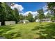 Large backyard and green lawn with several detached garages and sheds at 1130 Rawlings Dr, Rutledge, GA 30663