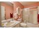 Pink bathroom featuring a sink, mirror, toilet and shower with glass doors at 1130 Rawlings Dr, Rutledge, GA 30663