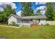 The home has a porch with awning and is surrounded by luscious greenery, including banana trees at 1130 Rawlings Dr, Rutledge, GA 30663