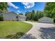 Side view of home with large lawn, driveway, and two detached garages on a sunny day with blue sky at 1130 Rawlings Dr, Rutledge, GA 30663