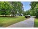 A view of the home and the detached garage from the partially wooded lot on a bright and sunny day at 1130 Rawlings Dr, Rutledge, GA 30663