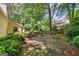 Lush backyard with mature trees, shrubs, and a glimpse of the house and deck at 1850 Linnet Ne Ct, Roswell, GA 30075