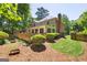 Exterior view of a home with a spacious wooden deck, lush bushes, and a well-manicured lawn at 1850 Linnet Ne Ct, Roswell, GA 30075