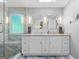 Bright bathroom with double vanity, granite countertops, modern lighting, and glass shower at 1850 Linnet Ne Ct, Roswell, GA 30075