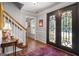 Welcoming foyer with hardwood floors, staircase, black front door, and elegant decorative details at 1850 Linnet Ne Ct, Roswell, GA 30075