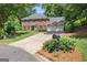 Traditional two-story brick home with a well-manicured lawn and a three-car garage at 1850 Linnet Ne Ct, Roswell, GA 30075