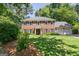 Charming two-story brick home featuring a well-manicured lawn, lush landscaping, and an attached two-car garage at 1850 Linnet Ne Ct, Roswell, GA 30075
