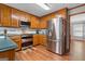 This spacious kitchen has wood cabinets, stainless steel appliances and hardwood floors at 1850 Linnet Ne Ct, Roswell, GA 30075