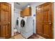 The laundry room has white appliances, custom cabinets, and hardwood floors at 1850 Linnet Ne Ct, Roswell, GA 30075