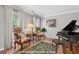 Cozy living room featuring hardwood floors, two windows, piano, and two stylish chairs with side table at 1850 Linnet Ne Ct, Roswell, GA 30075