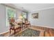 Cozy living room featuring hardwood floors, two windows, and two stylish chairs with side table at 1850 Linnet Ne Ct, Roswell, GA 30075