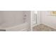 Modern bathroom featuring a white tub and glass-enclosed shower with tiled floors at 173 Aster Ave, Locust Grove, GA 30248