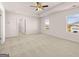 Spacious bedroom with carpet floors, ceiling fan and two large windows at 173 Aster Ave, Locust Grove, GA 30248