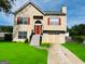 Charming two-story home with red accents, a well-manicured lawn, and a private driveway at 5814 Highgrove Dr, Atlanta, GA 30349