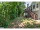 Expansive backyard featuring lush greenery and a wooden deck with staircase at 832 Windy Mill Ct, Temple, GA 30179