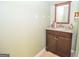 Bathroom featuring a wood cabinet with granite countertop and a decorative framed mirror at 832 Windy Mill Ct, Temple, GA 30179