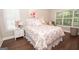 Cozy bedroom with hardwood floors, natural light, and a floral-patterned comforter, offering a peaceful retreat at 832 Windy Mill Ct, Temple, GA 30179