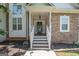 Inviting covered front porch with stone facade and classic white railing details at 832 Windy Mill Ct, Temple, GA 30179