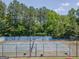Overhead view of a tennis court with surrounding trees and fencing at 832 Windy Mill Ct, Temple, GA 30179