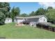 Rear exterior featuring a deck, fire pit, and ample yard space surrounded by lush trees at 8321 Banks Mill Rd, Douglasville, GA 30135