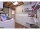 This basement laundry room has a washer and dryer, a small window, and storage shelves at 8321 Banks Mill Rd, Douglasville, GA 30135