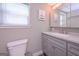 This bathroom has a toilet, a sink with countertop space, and a mirror above the sink at 8321 Banks Mill Rd, Douglasville, GA 30135