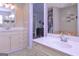 This bathroom has dual sinks with cream colored countertops, and a door to the walk-in closet at 8321 Banks Mill Rd, Douglasville, GA 30135
