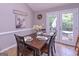 Cozy dining room with dark wood table set for four, artwork, and access to the outdoor deck via double doors at 8321 Banks Mill Rd, Douglasville, GA 30135
