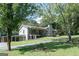 Exterior view of a home with a stone chimney, front porch, and attached carport at 8321 Banks Mill Rd, Douglasville, GA 30135