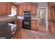 Traditional kitchen with warm wood cabinetry, granite counters and black appliances at 8321 Banks Mill Rd, Douglasville, GA 30135