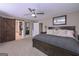 This main bedroom features a ceiling fan, carpet, and a sliding barn door leading to the main bathroom at 8321 Banks Mill Rd, Douglasville, GA 30135
