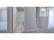 Hallway view to bathroom with white tub, toilet, and tile flooring at 609 Lobelia Way, Locust Grove, GA 30248