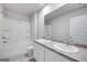 Bright bathroom featuring double sinks, large mirror, a tub with a shower, and a toilet at 609 Lobelia Way, Locust Grove, GA 30248