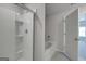 Bright bathroom featuring a glass-enclosed shower, a soaking tub, and tiled walls at 609 Lobelia Way, Locust Grove, GA 30248