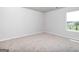 Bedroom featuring neutral carpet, light walls, and a bright window at 609 Lobelia Way, Locust Grove, GA 30248