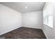 Bright and airy bedroom featuring hardwood floors, a large window, and fresh white walls at 609 Lobelia Way, Locust Grove, GA 30248