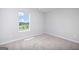 Bedroom with neutral carpet, light walls, and a window overlooking the neighborhood at 609 Lobelia Way, Locust Grove, GA 30248