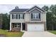 Charming two-story home featuring a brick-accented front, a two-car garage, and a well-manicured lawn at 609 Lobelia Way, Locust Grove, GA 30248