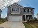 Charming two-story home featuring a two-car garage, gray siding and brick accents, complemented by a well-manicured lawn at 609 Lobelia Way, Locust Grove, GA 30248