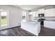 Open kitchen with island, granite countertops, and stainless appliances next to an outdoor view at 609 Lobelia Way, Locust Grove, GA 30248