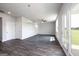 Bright living room featuring dark hardwood floors, modern chandelier and fan, and large windows at 609 Lobelia Way, Locust Grove, GA 30248