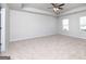 Spacious main bedroom with a trey ceiling, a ceiling fan, and two windows at 609 Lobelia Way, Locust Grove, GA 30248