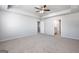 A bright main bedroom with carpet and open doors to a bathroom and closet at 609 Lobelia Way, Locust Grove, GA 30248