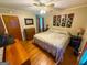 This bedroom features hardwood floors, ceiling fan, a dresser, and unique wall decorations at 5141 Hiram Lithia Springs Rd, Powder Springs, GA 30127