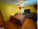 This bedroom features hardwood floors, yellow walls, and a ceiling fan at 5141 Hiram Lithia Springs Rd, Powder Springs, GA 30127
