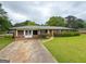 Lovely brick home featuring a well-maintained lawn, mature trees, and a concrete driveway at 5141 Hiram Lithia Springs Rd, Powder Springs, GA 30127