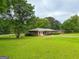 Expansive front yard with mature trees and a well-maintained lawn, showcasing the home's curb appeal at 5141 Hiram Lithia Springs Rd, Powder Springs, GA 30127